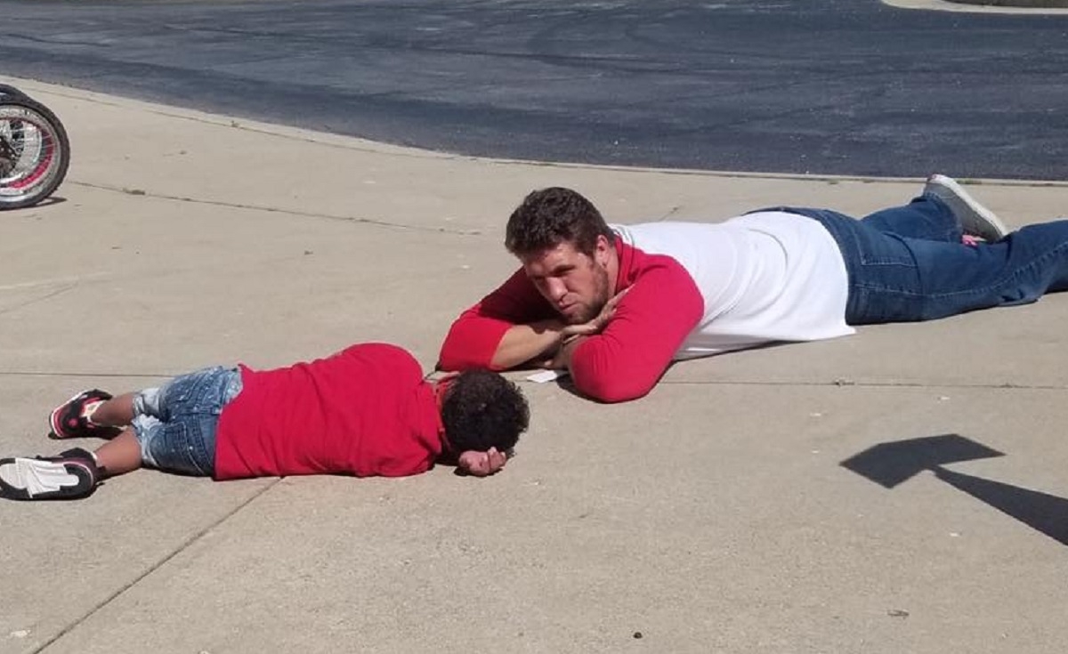 Un professeur s'allonge près d'un enfant autiste dans la cour d'école pour le calmer